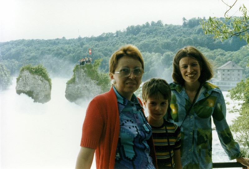 x-06 Ruth and our hosts, my cousin Max's wife Marie-Claire and their son Robert, on the upstream overlook. Behind them you can see tourists on the central rock, beneath a Swiss flag.