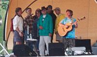 lavin Me (green raincoat) on stage with Christine Lavin doing 